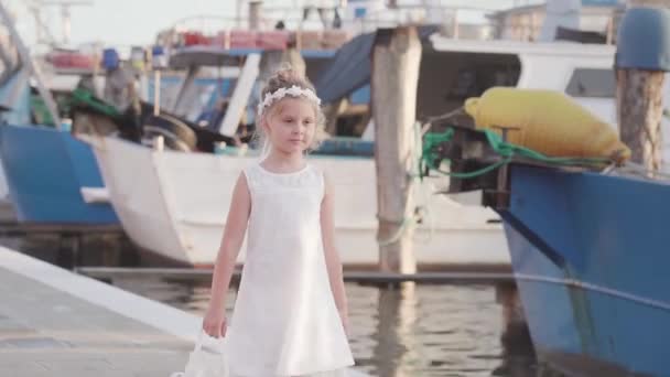 Beyaz Elbiseli Küçük Kız Balıkçı Teknelerinin Önünde Yürüyor — Stok video