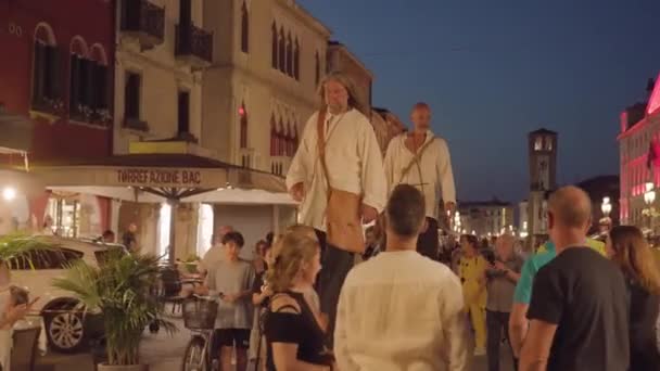 Chioggia イタリア 8月18 2022 背の高い男性が夕暮れ時に明るい光とチオジアの混雑した通りの階段を歩く 8月18日に開催される伝統行事 — ストック動画