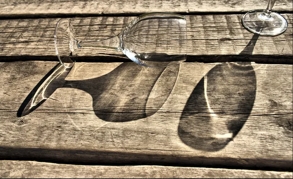 Glass goblet lies on the old boards — Stock Photo, Image