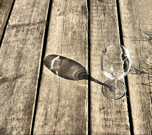 Glass goblet lies on the old boards — Stock Photo, Image