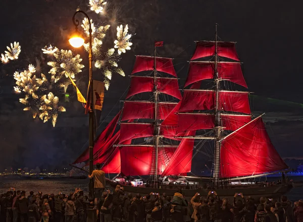 Lichtshow en vuurwerk met een fregat met dieprode zeilen drijvend op de rivier de neva. — Stockfoto