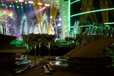 Şarap bardakları masanın üzerinde beyaz bir masa örtüsünün üzerinde. Yeni yıl kutlamalarından önce.