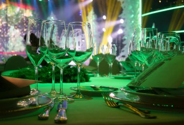 Şarap bardakları masanın üzerinde beyaz bir masa örtüsünün üzerinde. Yeni yıl kutlamalarından önce.