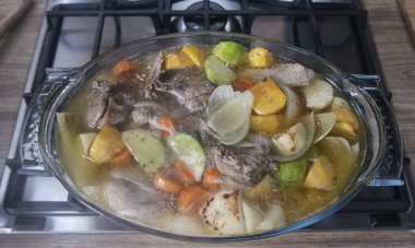 Gaz ocağında kızartma tavası. Şef pişirme işlemini kontrol ediyor. Gaz sobasında pişirme. Avrupa 'da pahalı gaz.