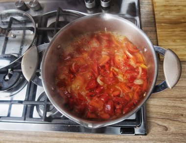 Gaz ocağında kızartma tavası. Şef pişirme işlemini kontrol ediyor. Gaz sobasında pişirme. Avrupa 'da pahalı gaz.