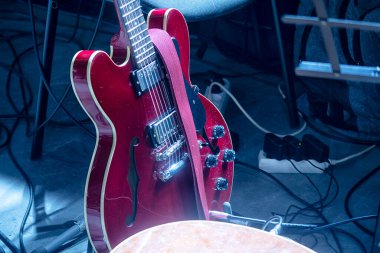 Sahnede sahne ışıkları altında konser öncesi elektro gitarlar..