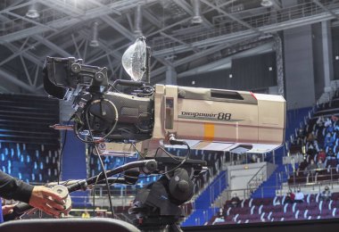 Profesyonel fotoğrafçı video ya da televizyon yayınları için tenis turnuvasındaki etkinlikten önce video kamera kurun ve hazırlayın.
