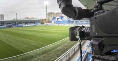 Profesyonel fotoğrafçıların video ya da televizyon yayınları için düzenlenen futbol turnuvasından önce video kamera kurun ve hazırlık yapın