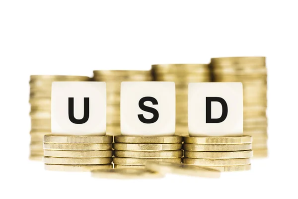 USD (Dollaro USA) sulle pile di monete d'oro isolate bianche — Foto Stock