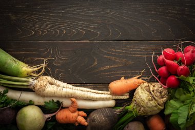 Ahşap arka planda kök sebzeler pancar, maydanoz, havuç ve organik çiftlik sebzeleriyle farklı turplar.