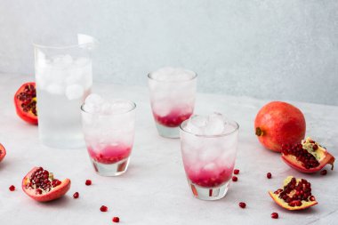 Nar suyu, nar tohumu ve buzla tazelenmiş bardaklarda, bir sürahi soğuk suyla narları çekirdekle keser.