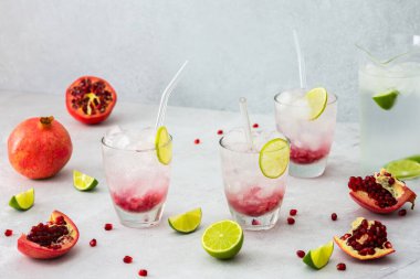 Nar tohumu, buz, kireç ve cam pipetlerle dolu bardaklarda serinletici nar içeceği, narlı sürahi soğuk su, çekirdekle kesilmiş nar.