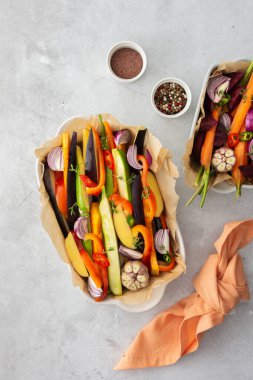 Çeşitli seramik tabaklarda fırında kızartılması için taze sebzeler, üst manzara.