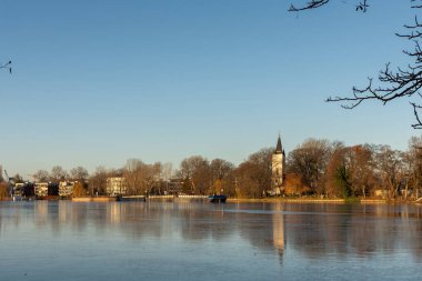 Berlin, Almanya - 26 Aralık 2021: Spree nehri boyunca bir yürüyüş ve Insel der Jugend adasından Treptower parkındaki diğer sahilin manzarası