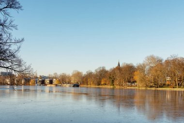 Berlin, Almanya - 26 Aralık 2021: Spree nehri boyunca bir yürüyüş ve Insel der Jugend adasından Treptower parkındaki diğer sahilin manzarası