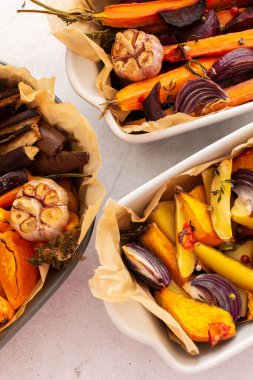 Fırında pişmiş taze sebzeler, çeşitli seramik tabaklarda sebzelerin üst görüntüsü.