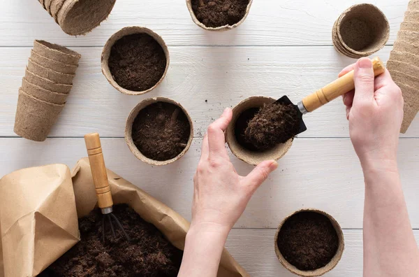 Mains féminines avec une pelle de jardin et le sol — Photo