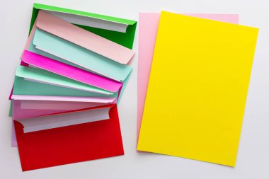 İçinde boş sarı kağıtlar, tebrik kartı veya davetiye kopyası olan çok renkli zarflar.