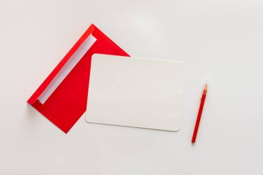 Boş kağıt ve kalemle kırmızı zarf, tebrik kartı veya davetiye modeli, üst görünüm, boşluk kopyala