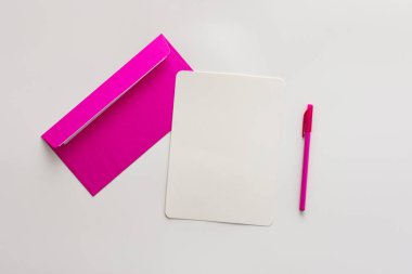 Boş kağıt ve kalemle pembe zarf, tebrik kartı veya davetiye kopyası, üst görünüm, boşluk kopyala