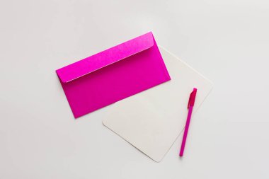 Boş kağıt ve kalemle pembe zarf, tebrik kartı veya davetiye kopyası, üst görünüm, boşluk kopyala
