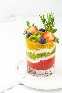 Meyveli, kivili ve mangolu meyve ve biberiyeli bardakta yoğurt.