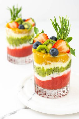 Meyveli, kivili ve mangolu meyve ve biberiyeli bardakta yoğurt.