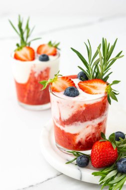 Lezzetli sağlıklı kahvaltı, çilekli smoothie ve doğal yoğurt ve yaban mersini ve biberiye.