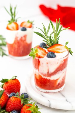 Lezzetli sağlıklı kahvaltı, çilekli smoothie ve doğal yoğurt ve yaban mersini ve biberiye.