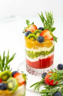 Meyveli, kivili ve mangolu meyve ve biberiyeli bardakta yoğurt.