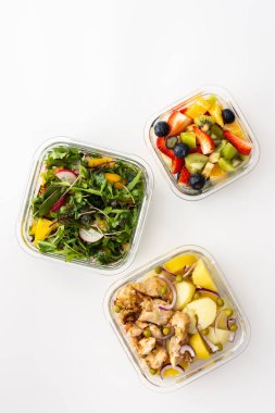 Ofis için ev yemeği, iş yerinde sağlıklı beslenme, tavuk göğsü, salata, meyve ve böğürtlen, üst görünüm.