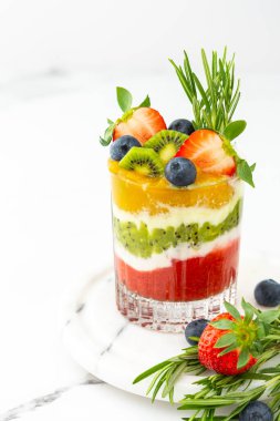 Meyveli, kivili ve mangolu meyve ve biberiyeli bardakta yoğurt.