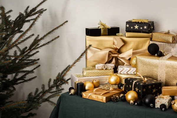 准备过节 准备圣诞树 黑金礼物 圣诞树旁桌上的圣诞玩具和装饰品 — 图库照片