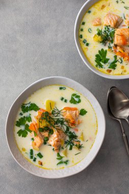 Norveç somon balığı çorbası. Sebzeli, otlu ve kremalı. Yemek masasının üstünde.