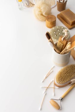 Seramik bardakta doğal tüyleri olan tahta diş fırçaları, yüz ve cilt bakım ürünleri, banyo aksesuarları, spa ve güzellik konsepti.