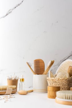 Seramik bardakta doğal tüyleri olan tahta diş fırçaları, yüz ve cilt bakım ürünleri, banyo aksesuarları, spa ve güzellik konsepti.