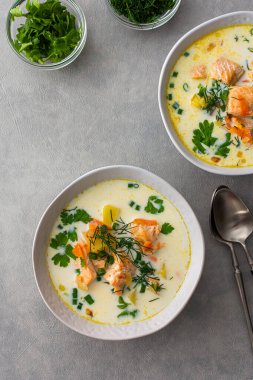 Norveç somon balığı çorbası. Sebzeli, otlu ve kremalı. Yemek masasının üstünde.