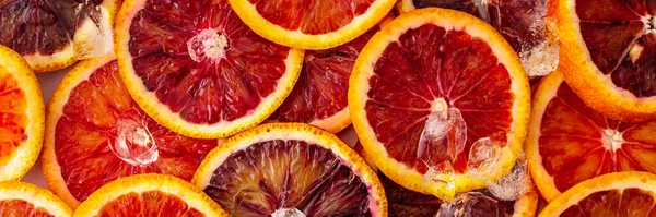 Fruit banner with blood oranges and ice, delicious sweet fruit, top view