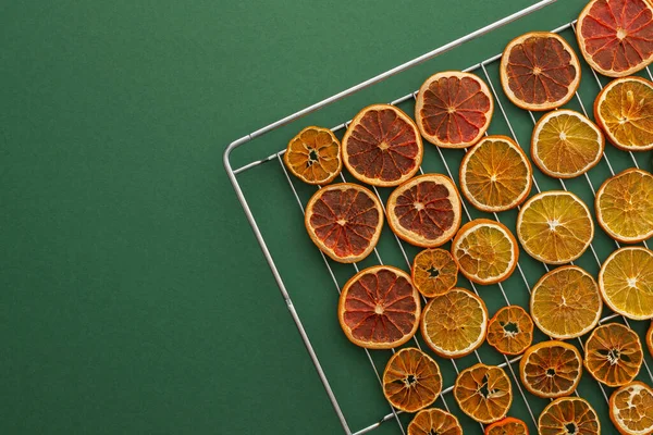 Oven dried sliced slices of orange, tangerine and grapefruit, dried citrus fruits on a wire rack, top view of fruits for Christmas garland