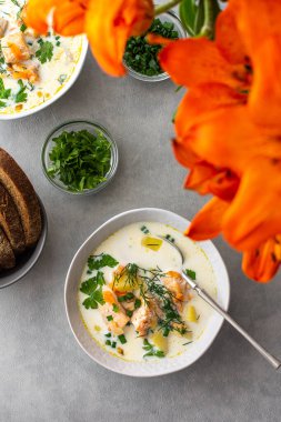 Norveç somon balığı çorbası. Sebzeli, otlu ve kremalı. Yemek masasının üstünde.