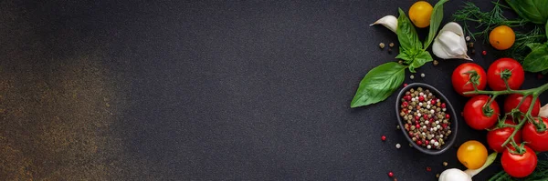 Food banner, fresh ripe red and yellow tomatoes, spices and basil leaves, garlic and green onions on a dark background, healthy food concept, copy space, top view