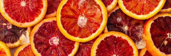 Fruit banner with blood oranges and ice, delicious sweet fruit, top view