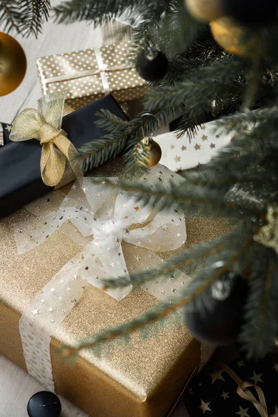 圣诞树下挂有蝴蝶结的黑色和金色礼品盒 圣诞快乐 新年快乐 — 图库照片