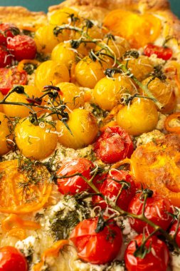 Ev yapımı börek ve sarı, turuncu ve kırmızı domatesler yeşil arka planda lezzetli kare turtalar, üst manzara, kopyalama alanı.