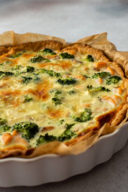 Homemade pie with red fish and broccoli, quiche with salmon and char, cheese and cream