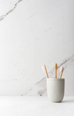 Seramik bardakta doğal kılları olan tahta diş fırçaları, doğal ağız hijyen ürünleri.