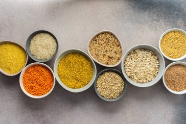 Hafif arka planda, kaselerde çeşitli tahıl gevrekleri, üst manzara