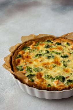 Homemade pie with red fish and broccoli, quiche with salmon and char, cheese and cream