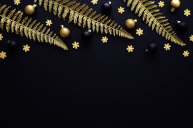 Altın renkli baston dalları, kar taneleri ve siyah arka planda Noel topları, Mutlu Noeller ve mutlu yıllar.