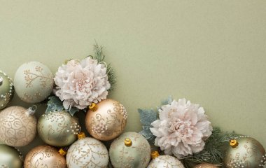 Yeşil arka planda Noel baloları ve dekoratif çiçekler Mutlu Noeller ve yeni yıl konsepti, üst manzara, kopyalama alanı